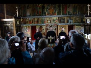 Winter Church - you see the   icon wall and a 3-person choir giving a brief concert