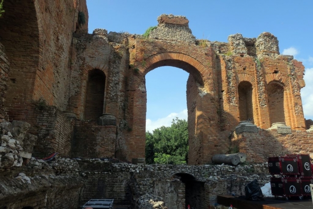 The Romans added this wall as a backdrop to the theater stage. Wee see brick, but it was originally covered with white marble.